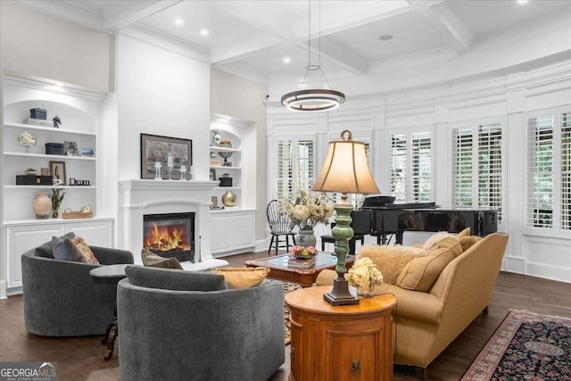 living room featuring beam ceiling, built in features, coffered ceiling, a glass covered fireplace, and wood finished floors