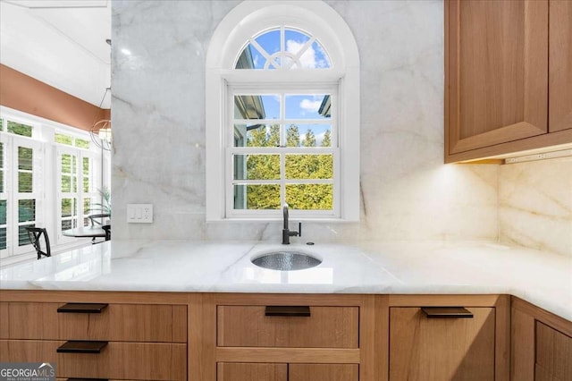 kitchen with a sink, decorative backsplash, and light countertops