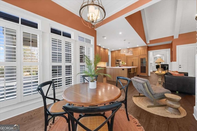 dining room with lofted ceiling with beams, a notable chandelier, wood finished floors, and recessed lighting