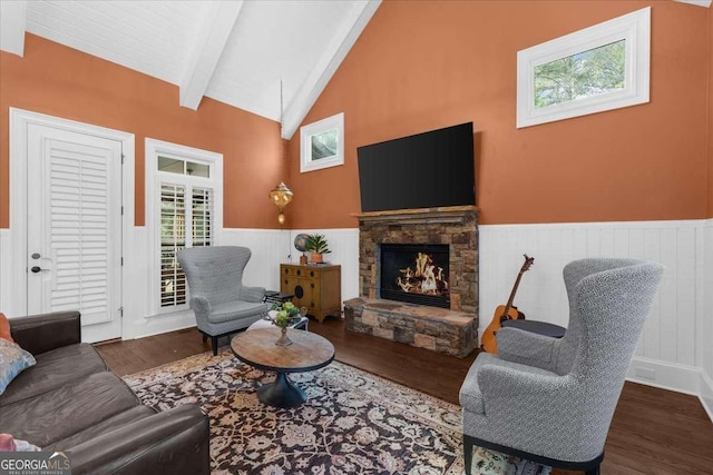 living room with a wainscoted wall, vaulted ceiling with beams, wood finished floors, and a fireplace