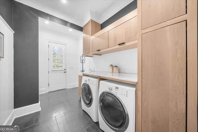 washroom featuring baseboards, cabinet space, washing machine and dryer, and crown molding