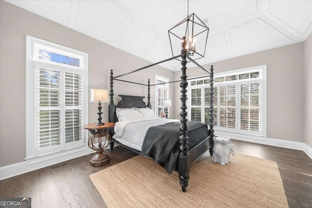 bedroom featuring visible vents, wood finished floors, baseboards, and a chandelier