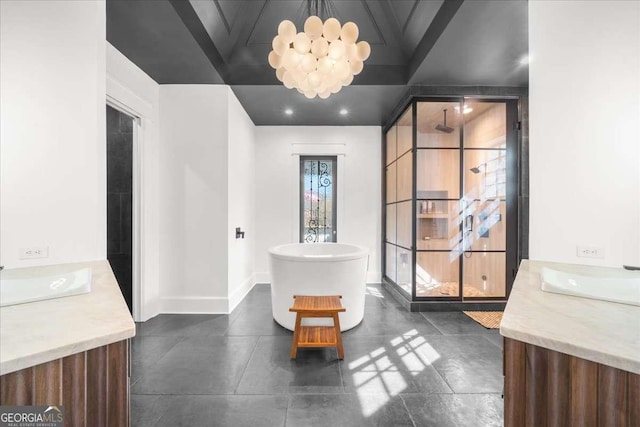 full bath with vanity, a freestanding tub, a notable chandelier, and baseboards