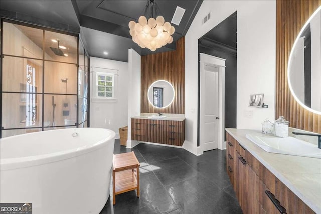 bathroom with visible vents, a freestanding tub, two vanities, a sink, and walk in shower