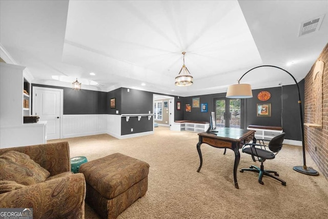 carpeted office featuring visible vents, a wainscoted wall, brick wall, and crown molding