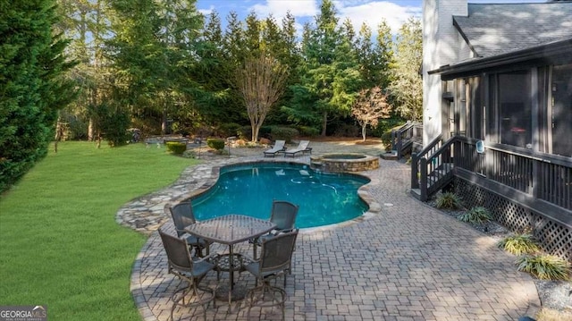 view of pool with a patio, a yard, and a pool with connected hot tub