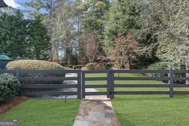 view of gate with a lawn and fence