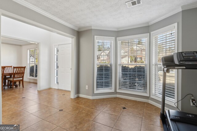 workout area with tile patterned flooring, visible vents, a healthy amount of sunlight, and crown molding