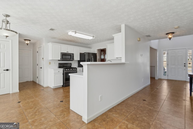 kitchen featuring light tile patterned floors, gas stove, visible vents, stainless steel refrigerator with ice dispenser, and white cabinetry