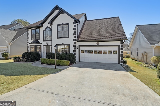 traditional-style home with a front yard, an attached garage, concrete driveway, and stucco siding