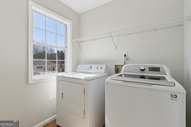 laundry room with laundry area, baseboards, and washing machine and clothes dryer