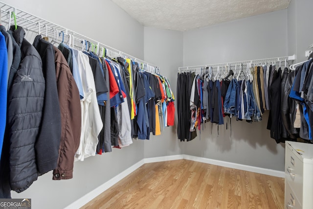 walk in closet with wood finished floors