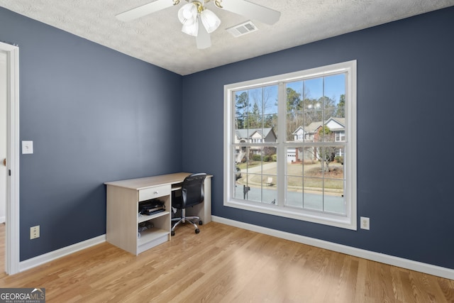 office area with visible vents, baseboards, a textured ceiling, and wood finished floors