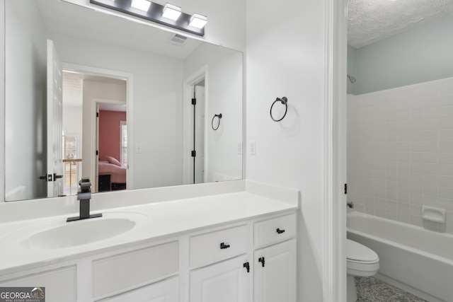 bathroom featuring connected bathroom, toilet, vanity, bathing tub / shower combination, and a textured ceiling