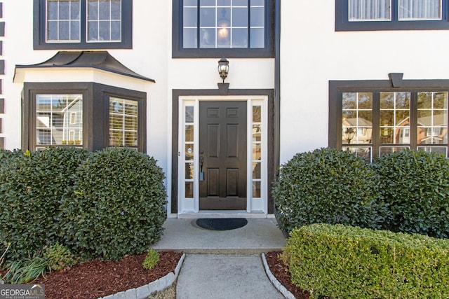 doorway to property featuring stucco siding