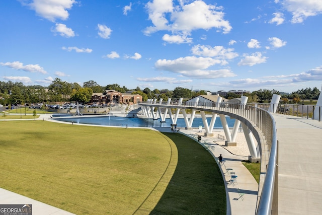 view of pool featuring a lawn