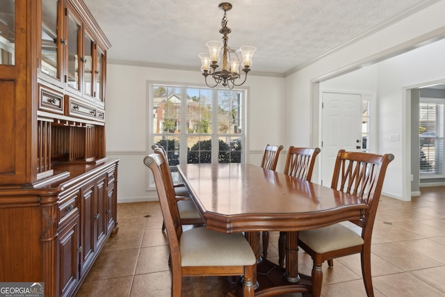 dining area featuring light tile patterned floors, a textured ceiling, and ornamental molding