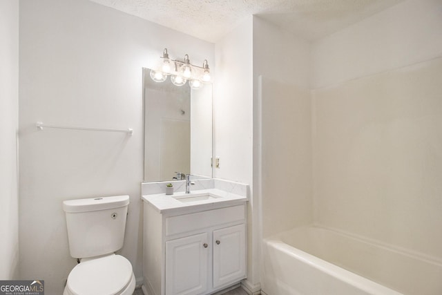 bathroom featuring a textured ceiling, bathtub / shower combination, vanity, and toilet