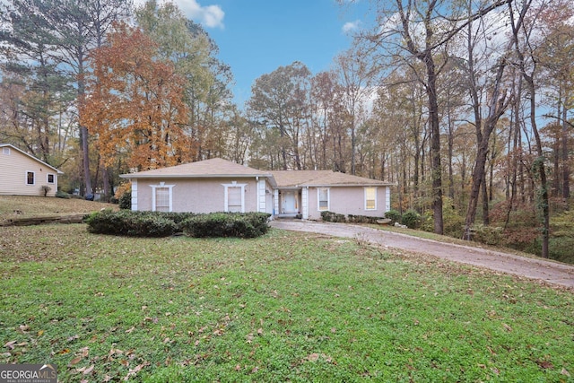 ranch-style house featuring a front lawn and driveway