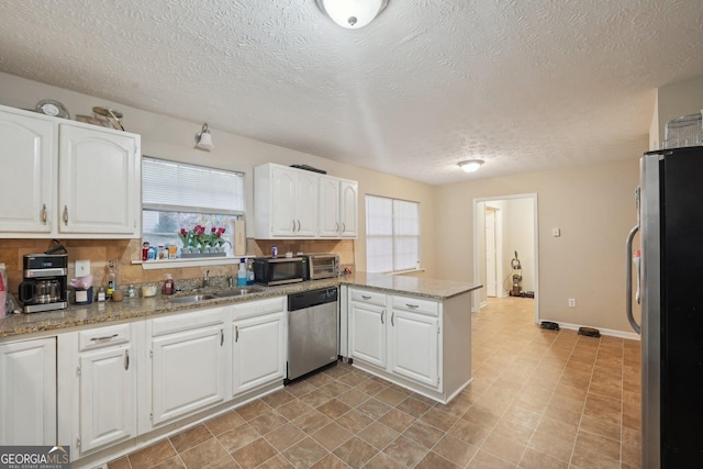 kitchen featuring a sink, a peninsula, white cabinets, and stainless steel appliances