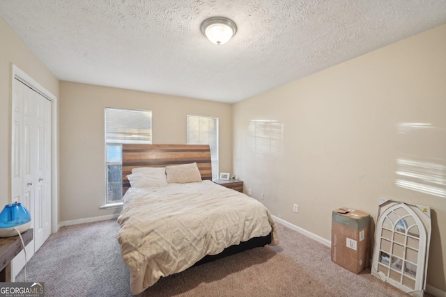 carpeted bedroom with baseboards, a closet, and a textured ceiling