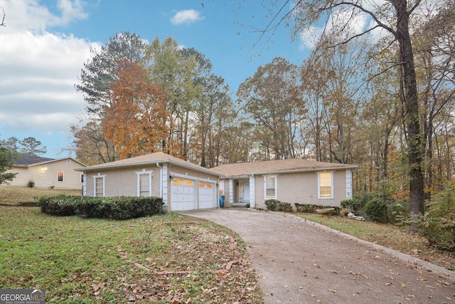 ranch-style house featuring a front yard, concrete driveway, a garage, and stucco siding