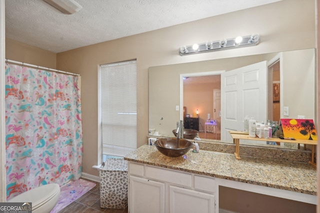 full bath featuring tile patterned floors, toilet, curtained shower, a textured ceiling, and vanity