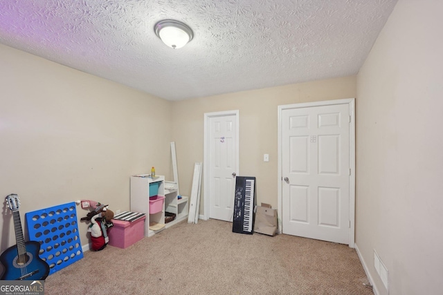 game room featuring visible vents, carpet, and a textured ceiling