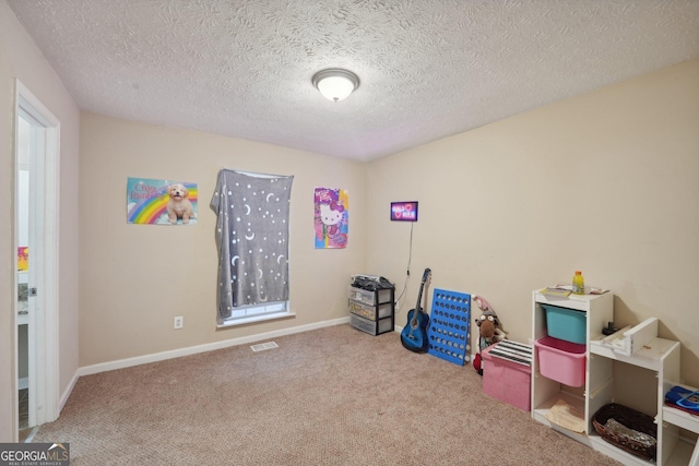 recreation room featuring carpet flooring, baseboards, visible vents, and a textured ceiling