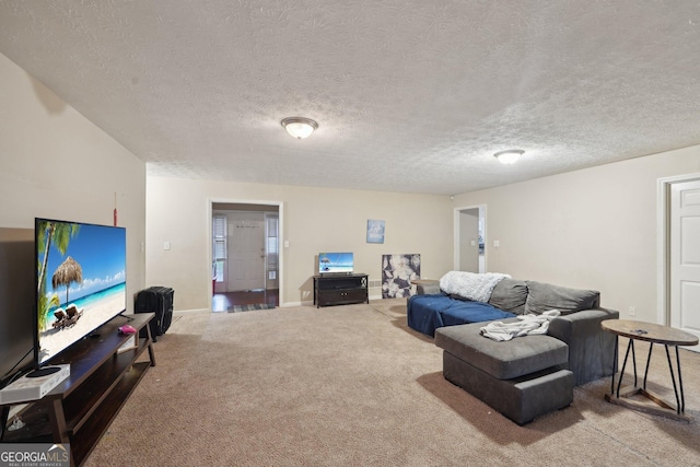 living area featuring baseboards, carpet, and a textured ceiling