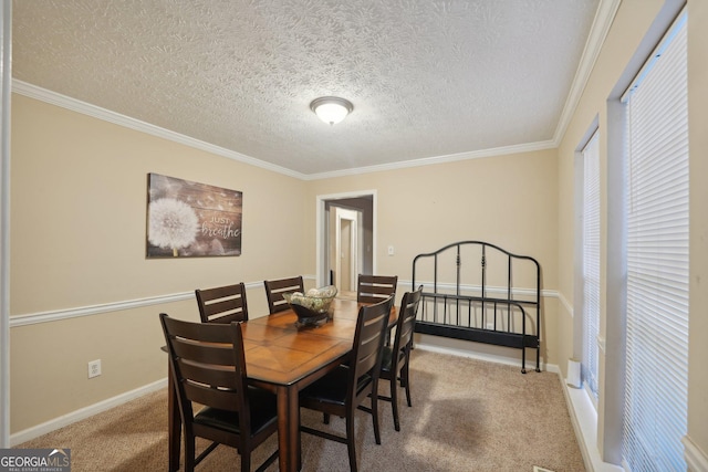 carpeted dining area with a textured ceiling, crown molding, and baseboards