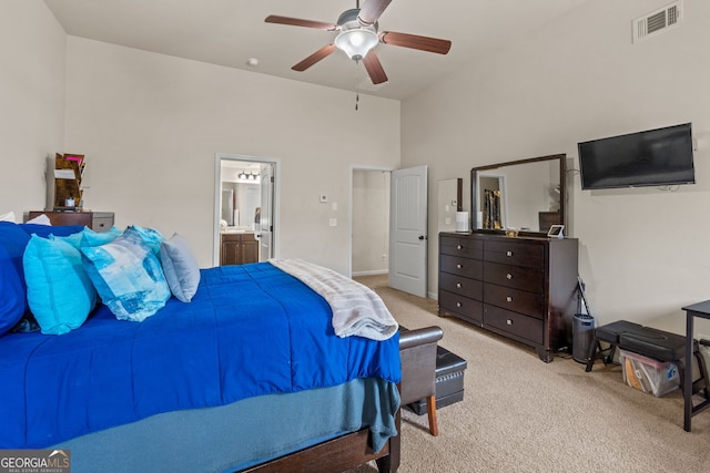 bedroom featuring visible vents, ceiling fan, light carpet, a towering ceiling, and ensuite bath