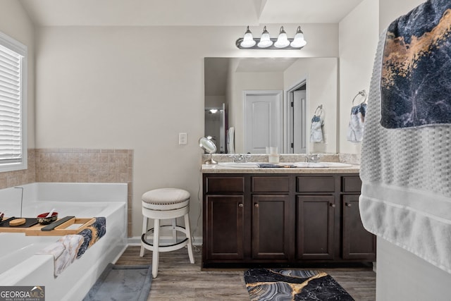 full bathroom featuring a bath, a sink, double vanity, and wood finished floors