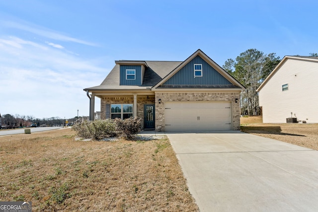 craftsman-style house featuring brick siding, board and batten siding, central AC, a garage, and driveway