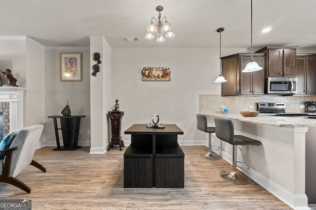 kitchen with decorative backsplash, dark brown cabinetry, light wood finished floors, and appliances with stainless steel finishes