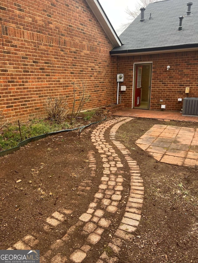 view of yard featuring central air condition unit and a patio