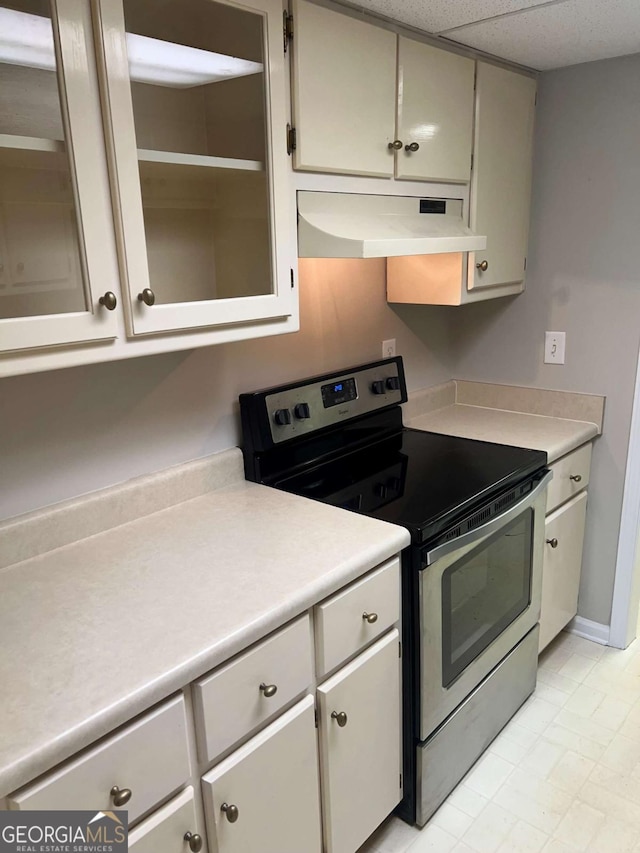 kitchen featuring light countertops, stainless steel range with electric stovetop, a paneled ceiling, and under cabinet range hood