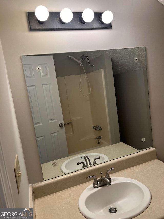 bathroom featuring shower / washtub combination and vanity