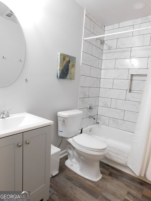 bathroom with shower / bath combination with curtain, toilet, vanity, and wood finished floors