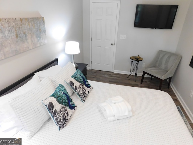 bedroom with wood finished floors and baseboards