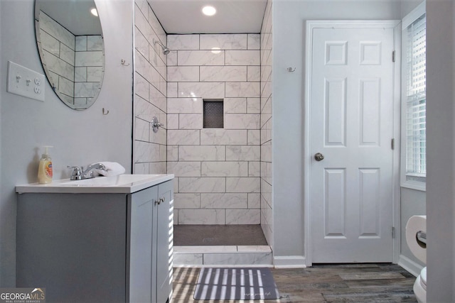 bathroom with toilet, vanity, walk in shower, and wood finished floors