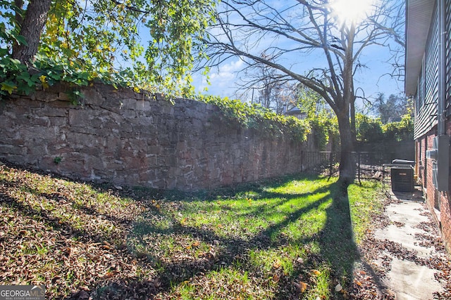 view of yard with central AC and a fenced backyard