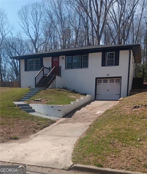 view of front of house featuring concrete driveway, an attached garage, and stucco siding