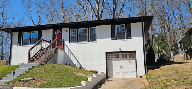 view of front of house featuring a garage, brick siding, concrete driveway, and fence