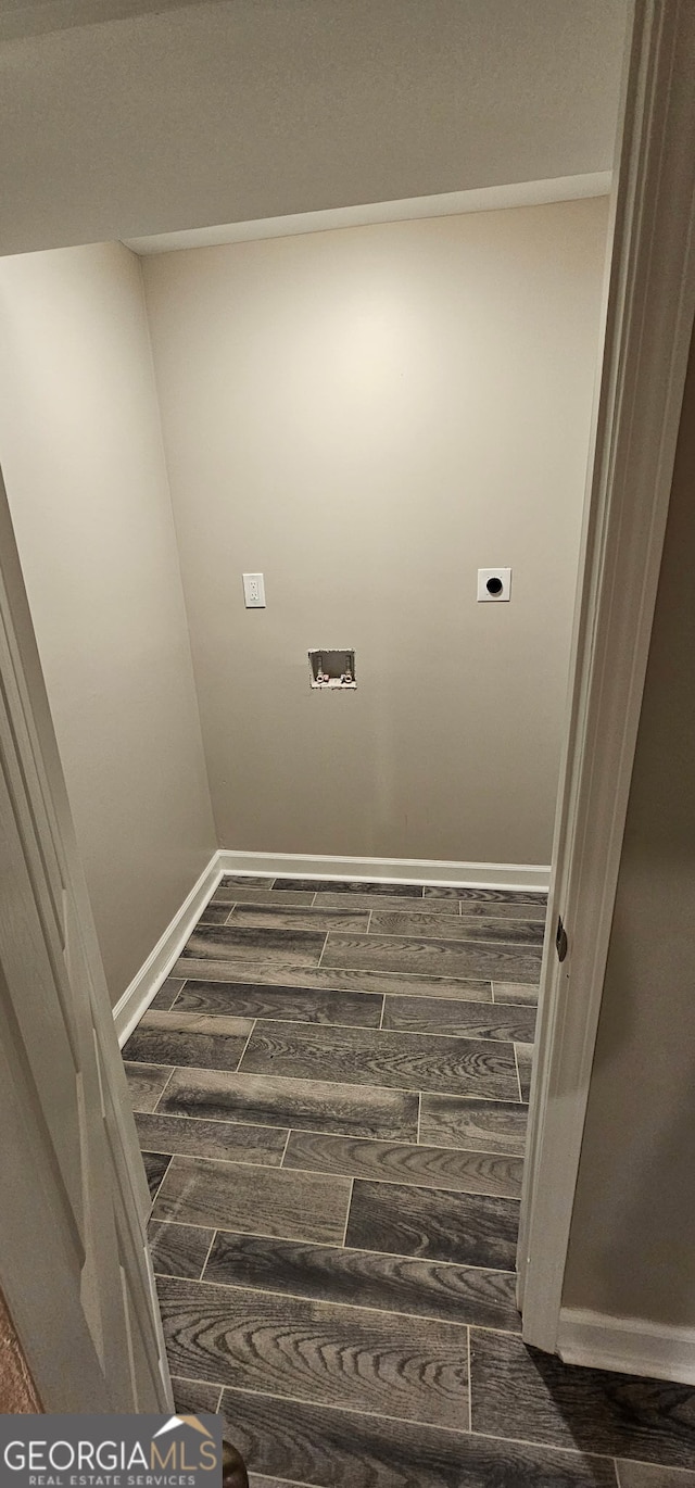 clothes washing area with dark wood-style floors, laundry area, hookup for an electric dryer, and baseboards