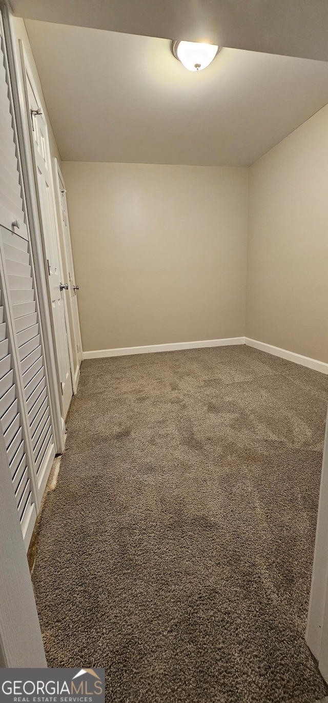 carpeted empty room with baseboards