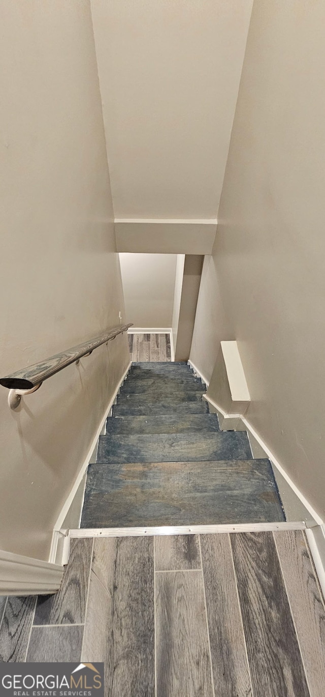 stairway with wood finished floors and visible vents