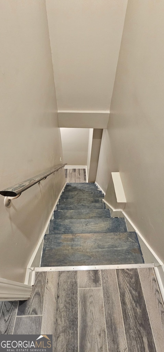 stairway featuring visible vents and wood finished floors