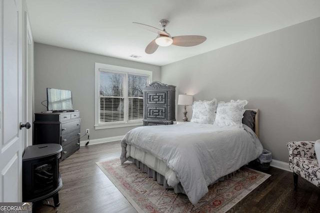 bedroom featuring ceiling fan, baseboards, and wood finished floors