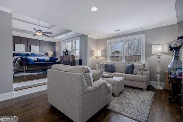 living room featuring wood finished floors, baseboards, visible vents, ceiling fan, and ornamental molding